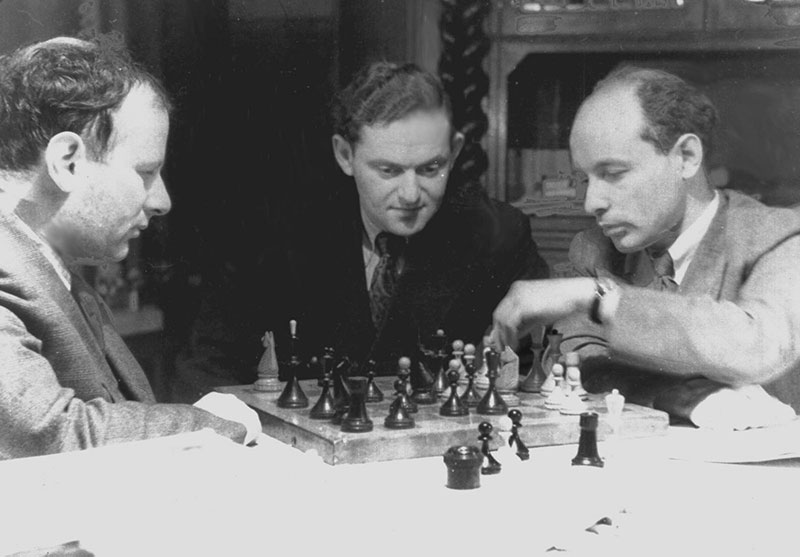 Isaac Boleslavsky, Semyon Furman, and David Bronstein ruminate over a board of Baku chessmen.